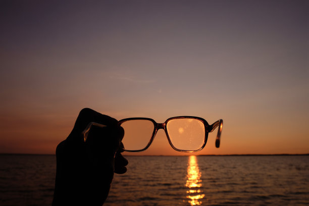 透过眼镜看到的落日。多云的眼镜。视力不佳。图片下载