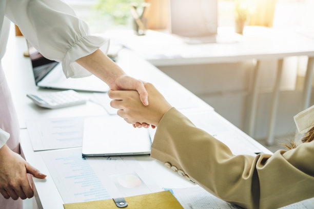 年轻的女商人与合作伙伴合作，增加他们的商业投资网络，计划下个月在他们的办公室提高质量。协议的概念。图片下载