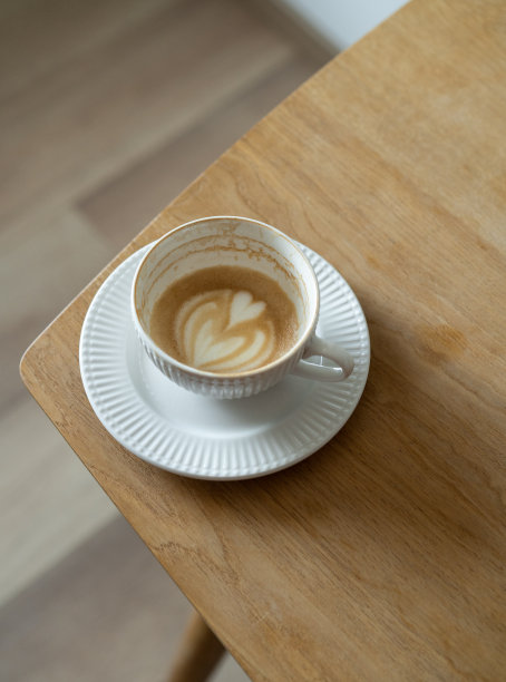 美丽的卡布奇诺拉花艺术图片在木桌子咖啡师图片下载