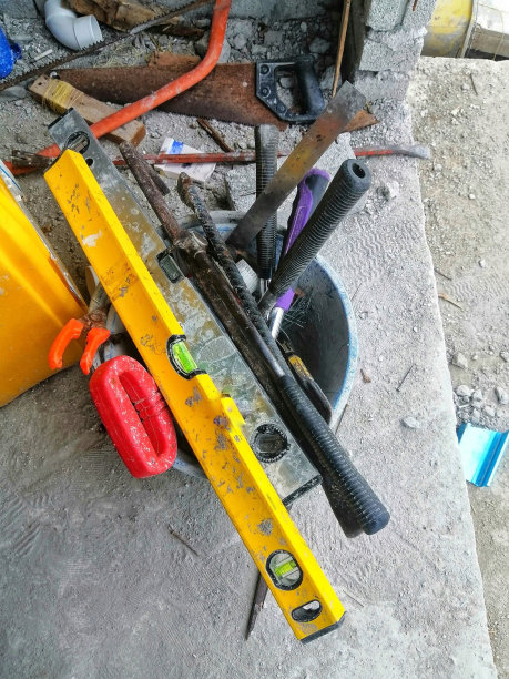 一堆建筑工具在现场的一个桶里。建造房屋的重要工具。图片下载