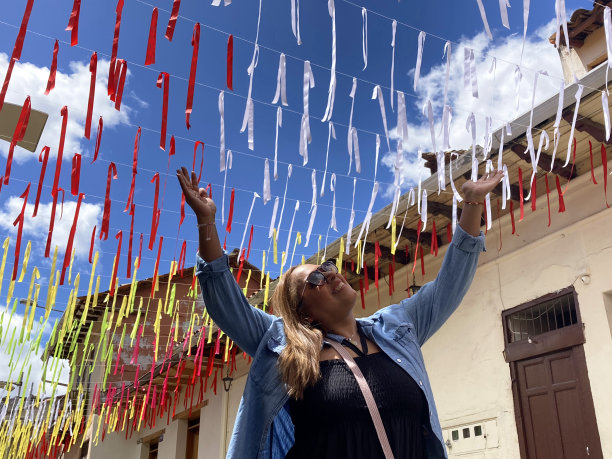 成熟的非洲裔拉丁女性背包客旅行，徒步旅行和享受在她的假期时间，摆出的照片肖像与她张开的双臂，在昆卡，阿祖伊省，厄瓜多尔，拉丁美洲中午。图片下载