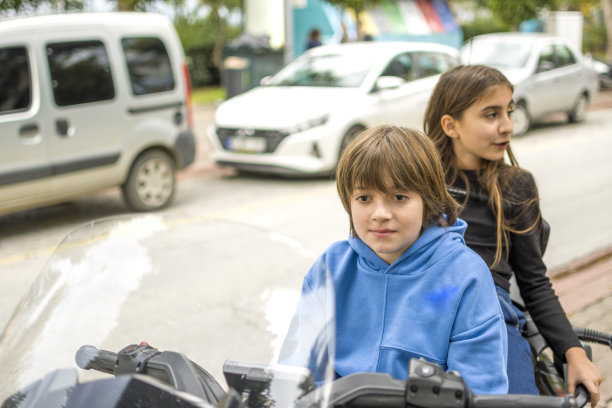 快乐的小男孩和小女孩骑着摩托车图片下载