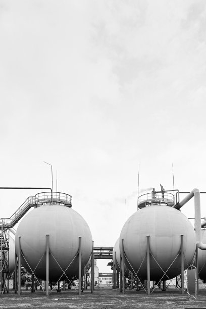 化工石化厂球形储气罐灰色天空下黑白BW垂直带copyspace。图片下载
