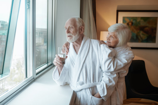 一对幸福的老夫妇站在旅馆的窗边图片下载