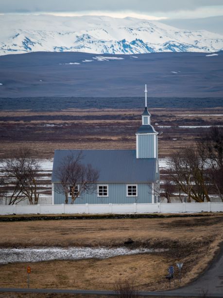 这是一张户外照片，在雪山旁边的平原上有一个小教堂图片下载