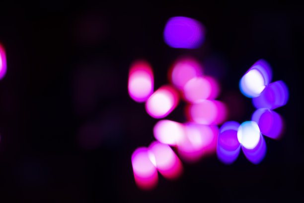 在黑色背景上，粉红色和紫色的高光和散景。图片下载