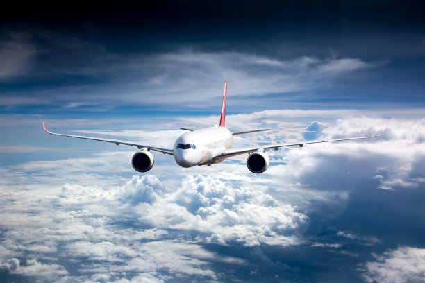 客机在云层上方高高飞行。前视图。图片下载