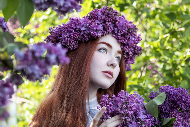 春天的花园里，一头长长的红头发，头上戴着紫丁香花环的年轻女孩图片下载