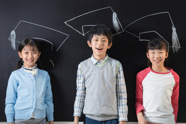 站在黑板前的快乐小学生图片下载