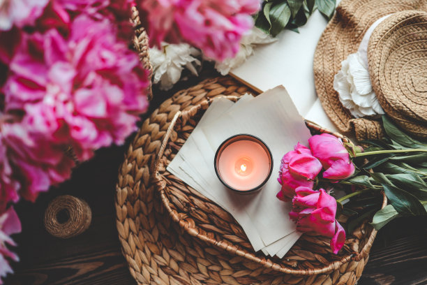 惬意的春天构图，燃烧的蜡烛，牡丹和帽子图片下载