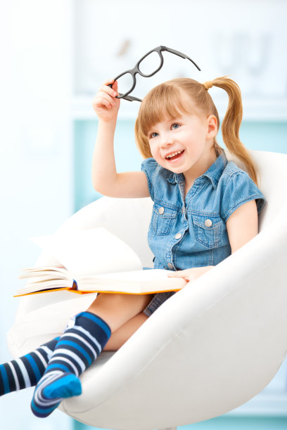 带着书和眼镜微笑的小女孩图片下载