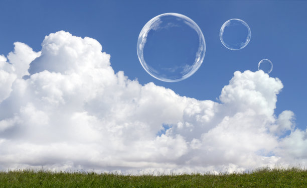 漂浮的肥皂泡对晴朗阳光下的蓝天和云图片下载