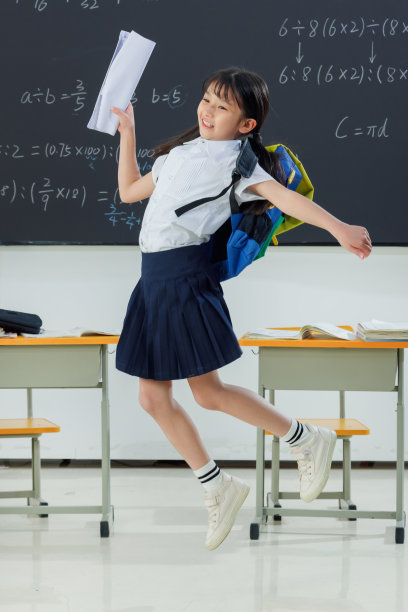 快乐的小学女生在教室里欢呼跳跃图片下载