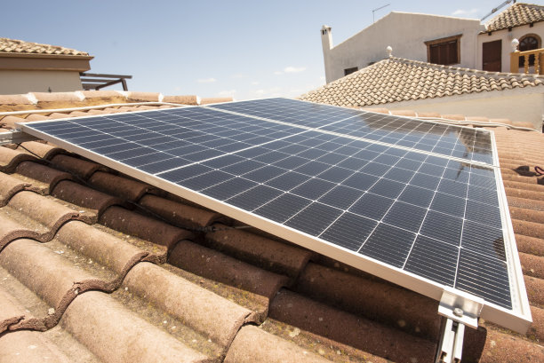 阳光明媚的日子里，太阳能电池板安装在屋顶上，典型的房屋屋顶图片下载