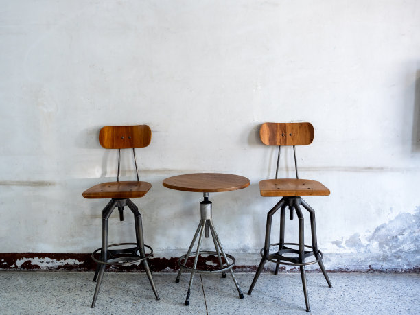 空的复古纺纱椅靠背，座位和圆形纺纱边桌装饰在旧白墙背景，阁楼风格的建筑内部。旋转木桌套，木质和黑铁材质。图片下载