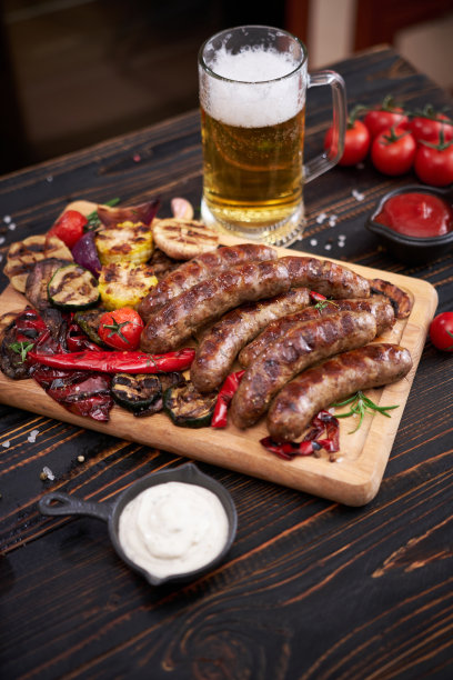 在家庭厨房的木制砧板上烤香肠和蔬菜图片下载