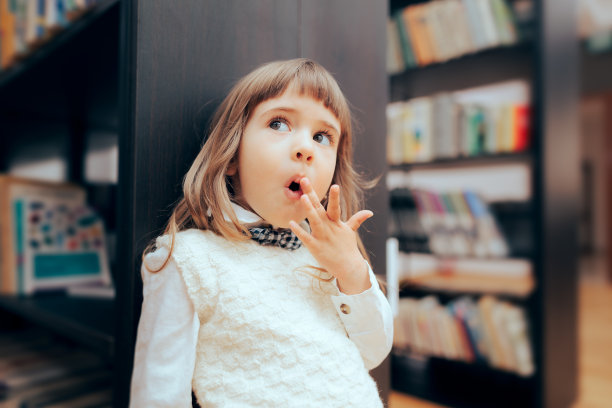 有趣的小女孩在图书馆看书图片下载