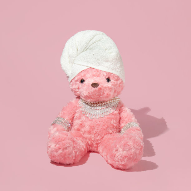 创意布局与粉红色的泰迪熊与毛巾头巾和奢侈品珠宝在柔和的粉红色背景。80或90年代复古时尚或生活方式的概念。美容新潮沙龙的想法。图片下载