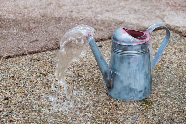 装满水的铁制水罐，准备给植物浇水。乡村园林春季园艺概念。花园喷泉的创意。设计自制的图片下载
