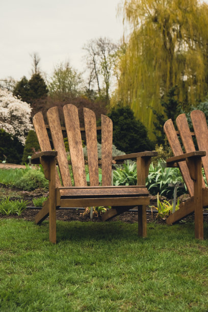 露台上的两个木制躺椅，绿色的植物，户外的花园家具，在夏天放松。园林景观与自然中的两把椅子。后院外图片下载
