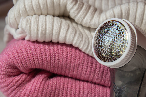 摇粒剃须刀。剃衣服的装置。防长毛绒织物剃须刀。电动便携式羊毛衫毛球除绒机，用于去除粉色腈纶或羊毛羊毛衫上的毛球。电动装置对织物进行剃须后的清洁并收集绒毛图片下载