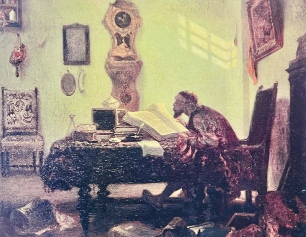 书呆子坐在桌子上读一本大书图片下载