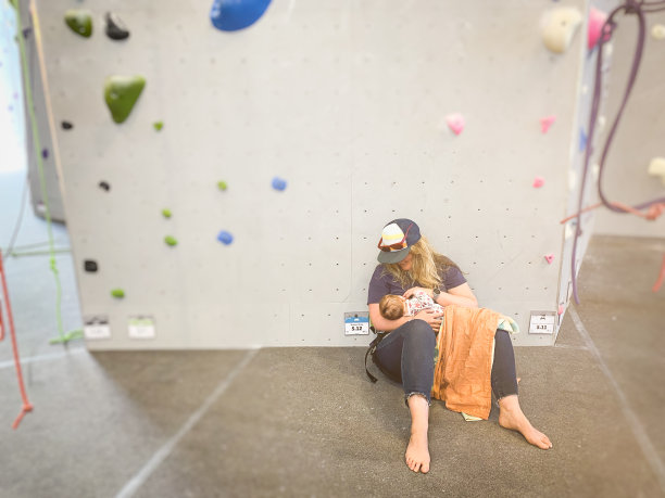 一位母亲在攀爬馆里给女儿喂奶图片下载