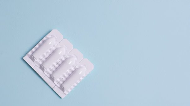 栓剂用于肛门或阴道使用的蓝色背景。蜡烛用于治疗痔疮，发烧，鹅口疮，炎症。图片下载
