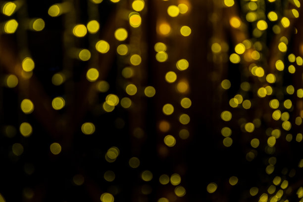 黑色背景上黄色灯光的抽象散景效果。圣诞灯图片下载