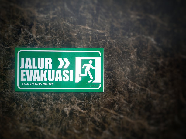 “疏散路线”的指示标志贴在瓷砖墙上图片下载