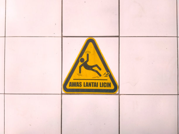 铺有瓷砖的地板上有“小心，地面湿滑”的警告标志图片下载