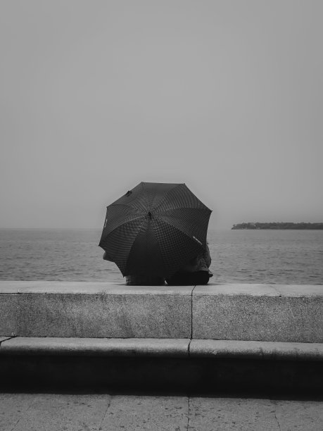 在雨天的海边，一对浪漫的情侣图片下载