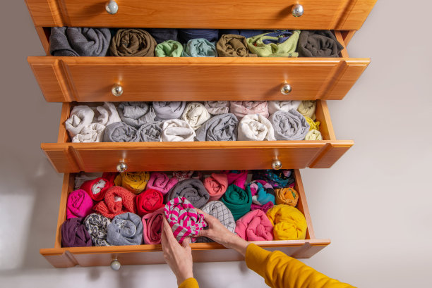 在衣柜里清洗和分类衣服的日本方法。打开衣柜抽屉与垂直存储扭曲的衣服。从以上观点。图片下载