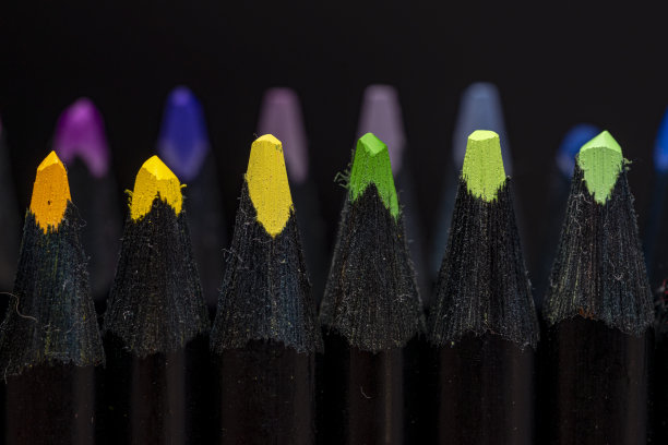 几支彩色铅笔，颜色鲜艳的笔尖有选择性聚焦，黑色背景。图片下载