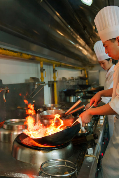 后厨内的专业厨师团队烹饪美味佳肴图片下载