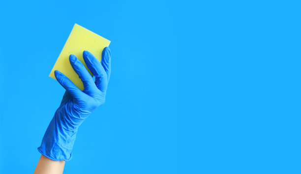 蓝色背景，女性手中用来洗碗的海绵图片下载