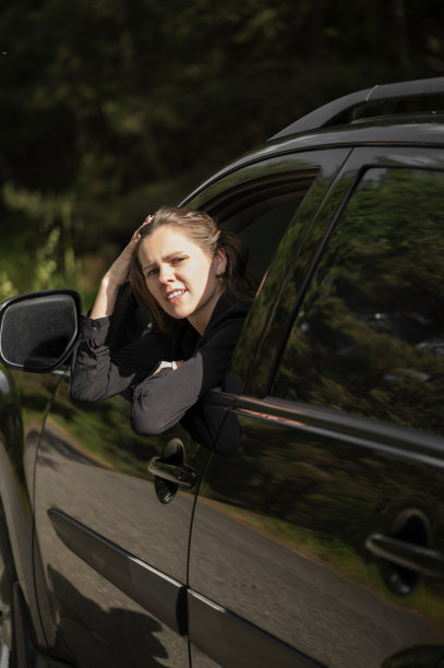 女孩坐在驾驶座上望向窗外图片下载