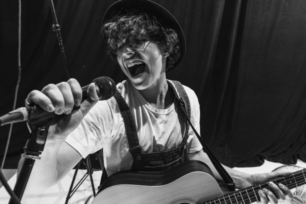 音乐工作室的复古乐队的重复。年轻的音乐家演奏吉他和唱歌。彩排基地。艺术概念，音乐，风格和创作图片下载