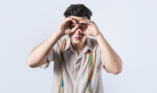 一个人在做双筒望远镜的手势，好奇的人在做双筒望远镜的手势，盖伊在孤立的背景上做双筒望远镜的手势，男人把他的拳头当双筒望远镜用图片下载