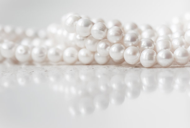 自然白色珍珠串在大理石背景软焦点图片下载