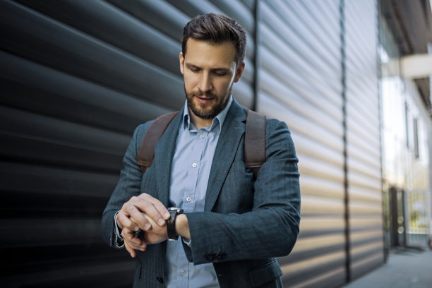 年轻的休闲商人正在看手表图片下载