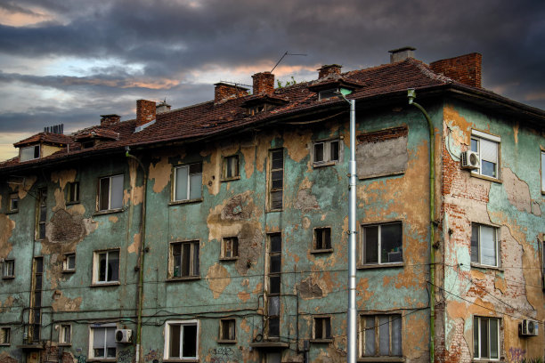 古老的废弃的幽灵般的豪宅，蓝绿色的屋顶和多云的灰色天空-室外的房子的一个恐怖或战争场景图片下载