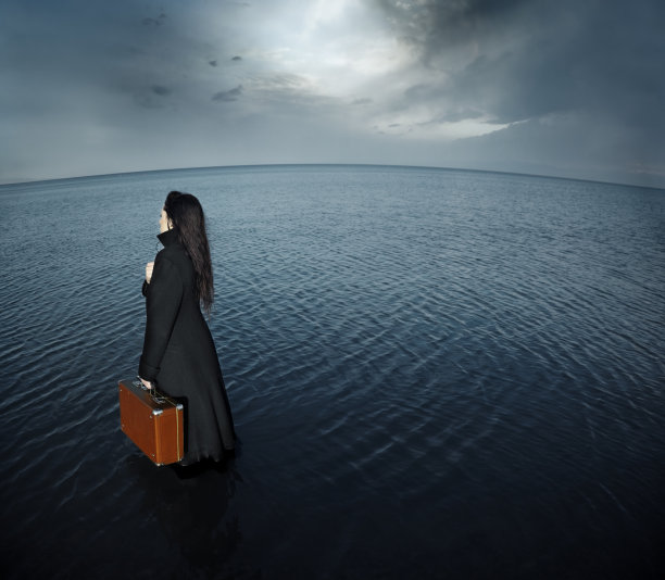 鱼眼照片，一个悲伤的女人带着旅行袋去大海图片下载