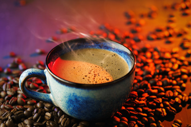 桌上放着一杯咖啡和烤好的咖啡豆，橘色和紫色的背光图片下载