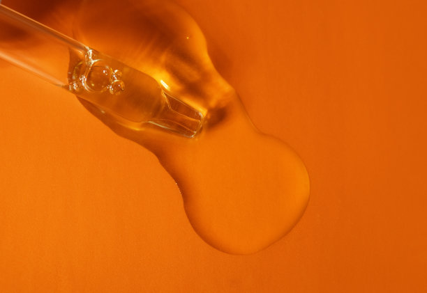 带液体透明质酸的移液管，橙色背景。化妆品和保健概念特写图片下载