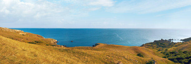 有小岩石泻湖和海岸草的海滩。图片下载