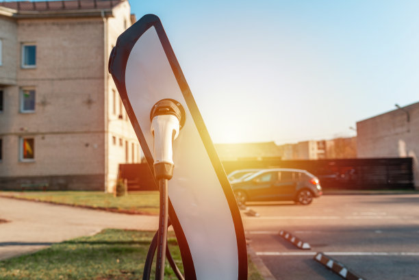 电动汽车电源线。绿色站。电动汽车蓄电池充电电源。早上的日出。有选择性的重点。图片下载