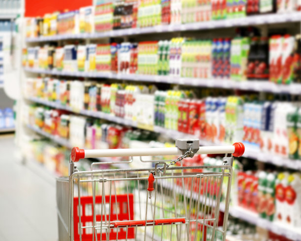 在超市挑选乳制品。空无一人的超市里的空购物车图片下载