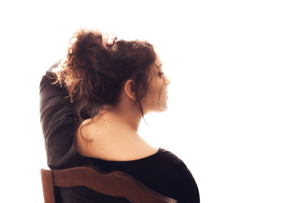 年轻而卷曲的女人用手托着她的头发图片下载