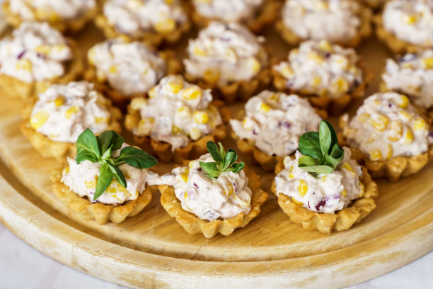 餐桌上摆满了小吃的照片。松饼和迷你三明治加蘑菇。图片下载